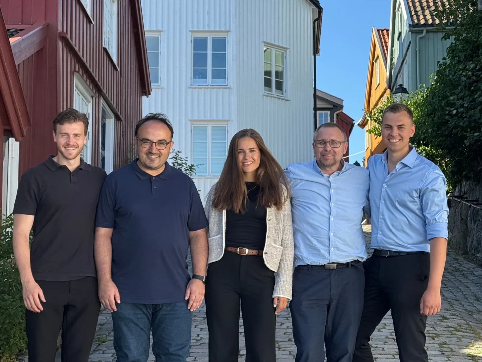 Team Gadder samlet foran trehus i en norsk bygate